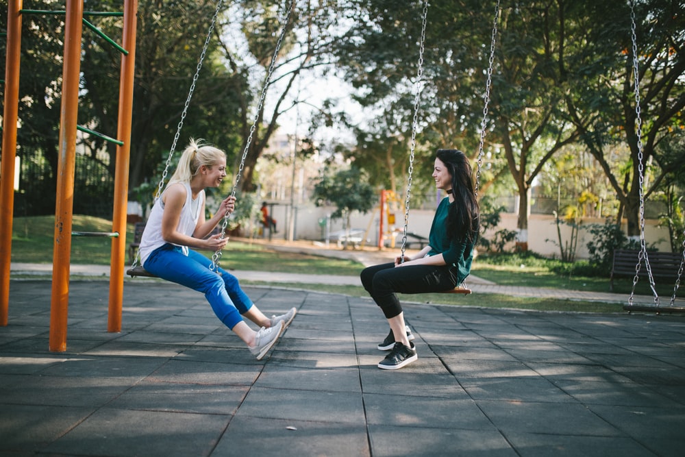 teenage girls sitting on swings photo by bewakoofofficial @ unsplash.com